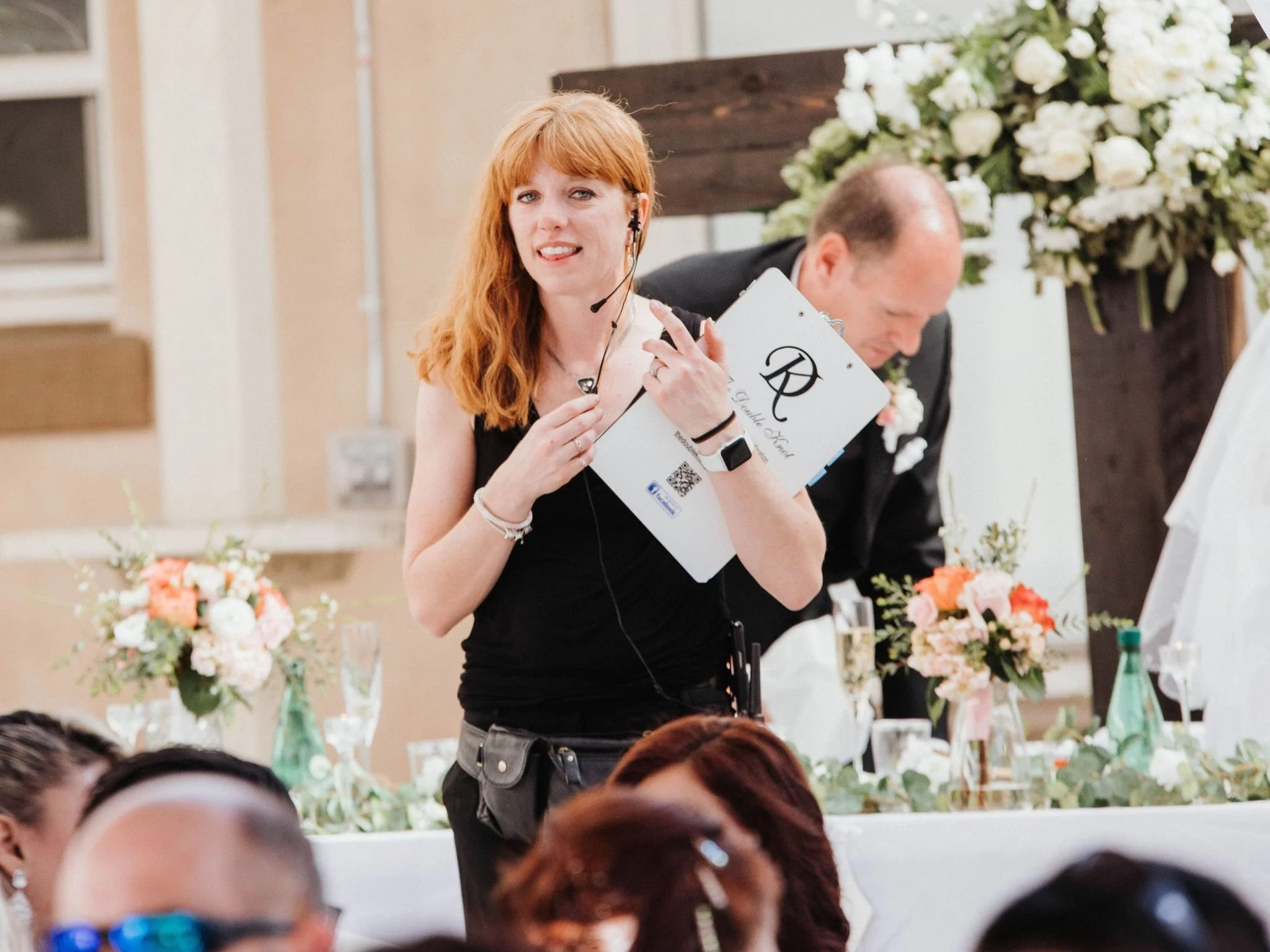 wedding coordinator with headset checking timeline at reception venue
