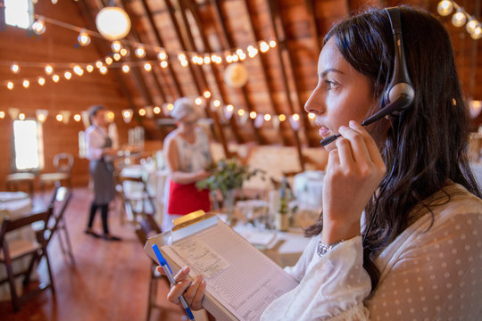 wedding planner with headset directing reception vendors