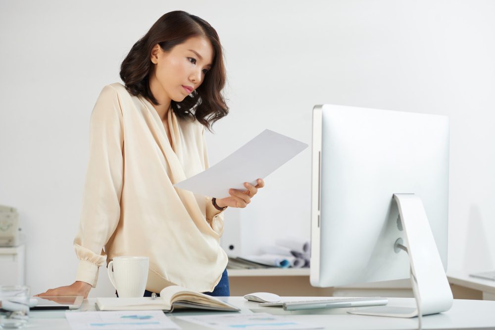 wedding planner reviewing invoice paperwork at desk