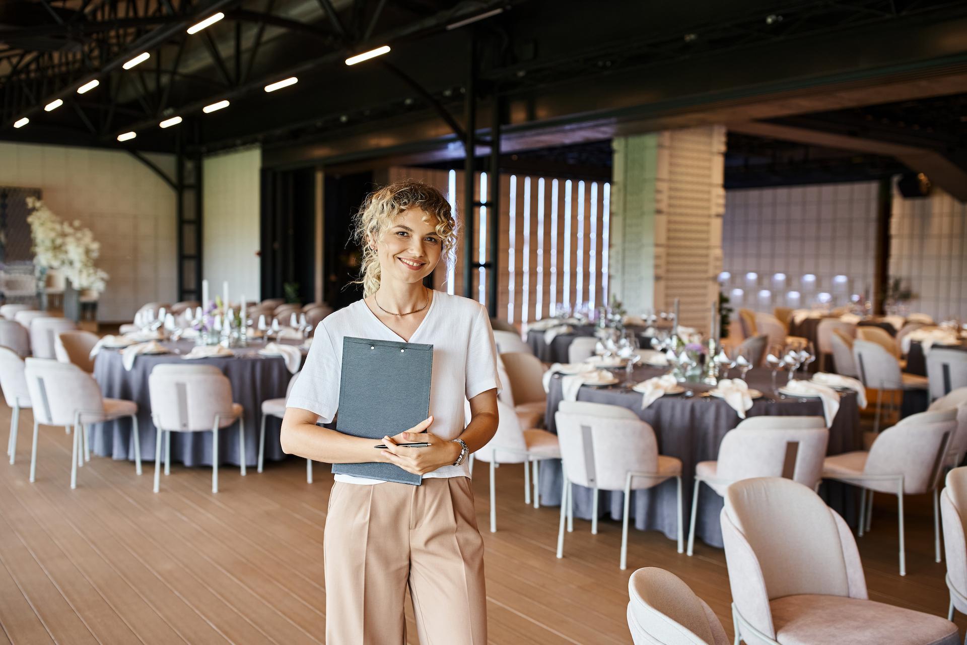 wedding planner walking through venue setup with clipboard