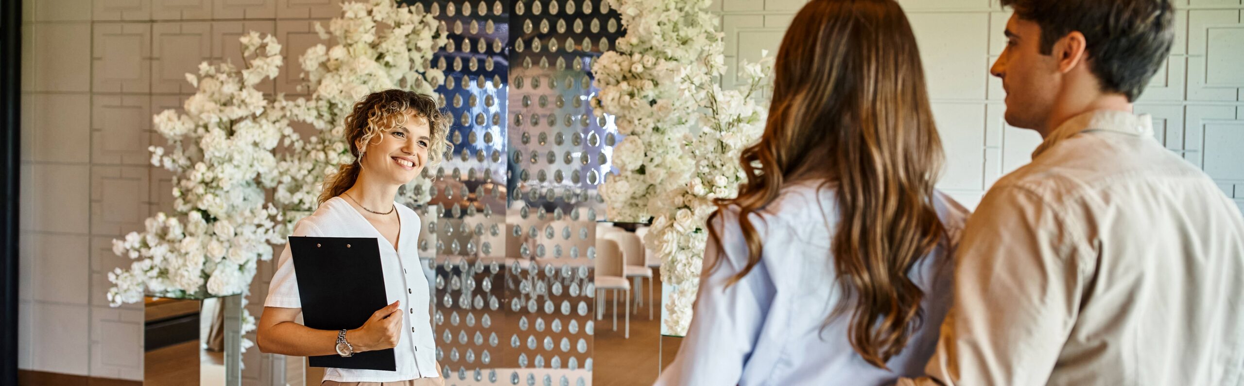wedding planner and couple touring empty reception venue
